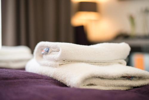 a pile of towels sitting on top of a bed at Goethe Conference Hotel by Trip Inn in Frankfurt