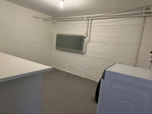 a room with a white wall with a radiator at Lantlig villa i Ljungbyhed in Ljungbyhed