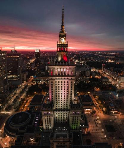 a large building with a clock tower on top of it at Super Apartament GREY Centrum 2x Metro Fast WiFi 300 Mbs Netflix AppleTV SmartTV Spotify Panorama Miasta in Warsaw