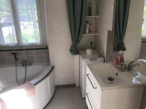 ein Badezimmer mit einer Badewanne, einem Waschbecken und einer Badewanne in der Unterkunft Maisonnette avec terrasse, jardin et poêle à bois in Pierrefitte-Nestalas
