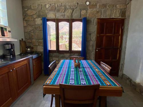 a kitchen with a table with a table cloth on it at Hospedaje Fortaleza Indigena in Tilcara
