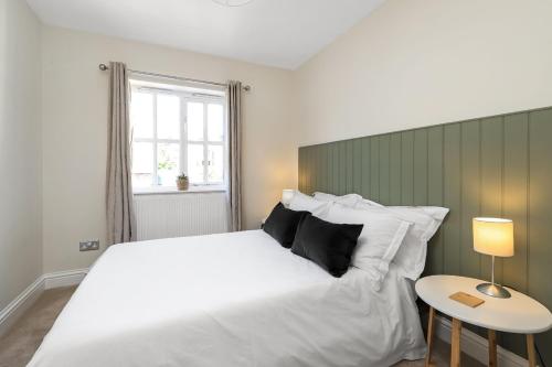 a bedroom with a large white bed and a table at Old School House, Winchester in Winchester