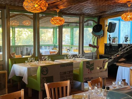 a dining room with tables and chairs and windows at La Calanque de Figuerolles in La Ciotat