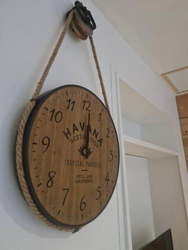 a wooden clock hanging on a wall at L'escale Charliendine in Charlieu