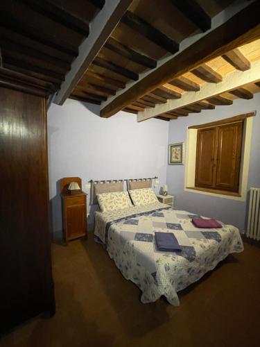 1 dormitorio con cama y techo de madera en Valdorcia, en San Quirico dʼOrcia