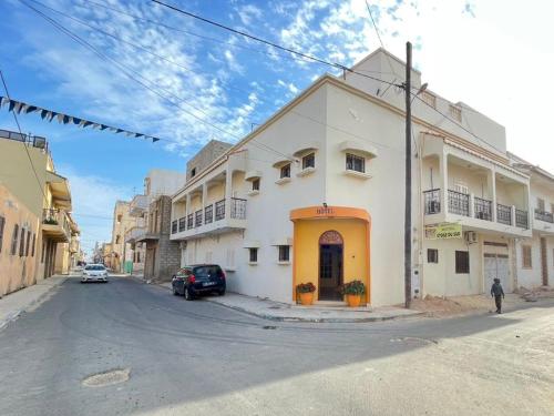 HÔTEL ETOILE DU SUD في سانت-لويس: مبنى ابيض على جانب شارع