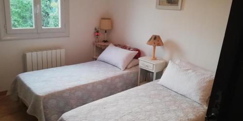 deux lits dans une petite pièce avec une fenêtre dans l'établissement Villa Graziella, à Châteauneuf