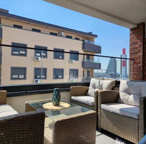 a balcony with chairs and a table on a building at APARTMAN FLORENCE in Mirijevo