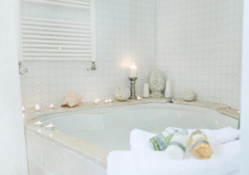 a white bath tub with a candle and a candle holder at Romantisches Haus im Schnoor in Bremen