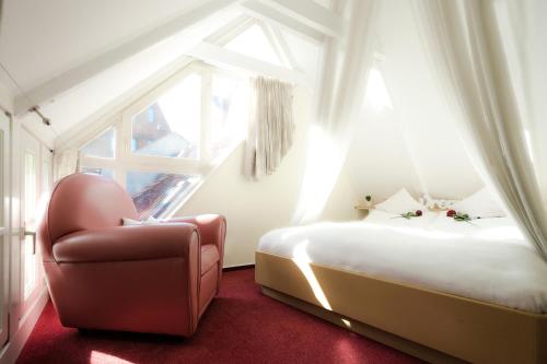 1 Schlafzimmer mit 2 Betten, einem Stuhl und einem Fenster in der Unterkunft Romantisches Haus im Schnoor in Bremen