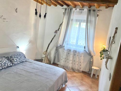 una camera con letto e finestra di B&B L'angolino a Usigliano