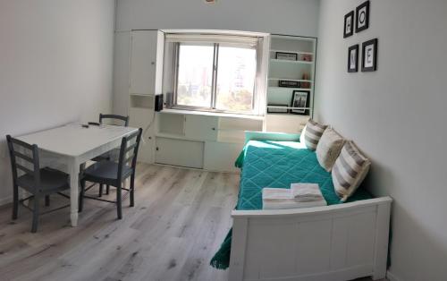 uma pequena sala de estar com uma mesa e um sofá em Departamento Del Plaza em Bahía Blanca