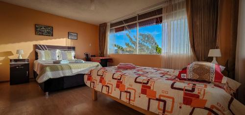 a bedroom with two beds and a large window at Casa huerta Stuber in Arequipa