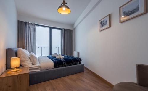 a bedroom with a bed and a large window at New Gudauri Twins in Gudauri