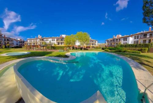 a large swimming pool in a yard with houses at APARTAMENTO MANUELA PROXIMO a GOLF ISLA CANELA LINKS in Ayamonte