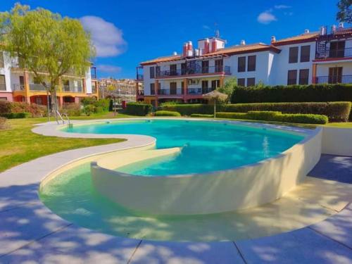 ein großer Pool in einem Hof mit Gebäuden in der Unterkunft APARTAMENTO MANUELA RESIDENCIAL **VISTA ESURI** in Ayamonte