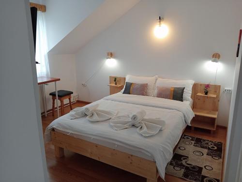 a bedroom with a white bed with bows on it at Casa Popa in Gura Humorului