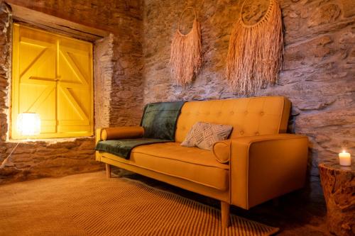 a living room with a couch and a yellow door at Lagos Com Sabor Guest House in Salgueiro