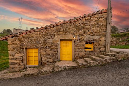 a stone building with two yellow doors and stairs at Lagos Com Sabor Guest House in Salgueiro