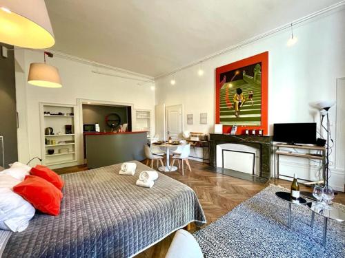 une chambre avec un lit et un salon dans l'établissement Appartements Caractere Clos St Jean, à Mâcon