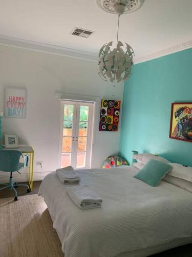 a bedroom with a bed and a desk and a chandelier at O'Briens of Clare - Stylish Pet Friendly Vineyard Accommodation in Clare