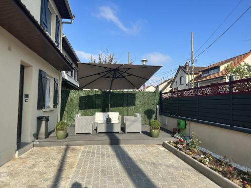 - une terrasse avec 2 chaises blanches et un parasol dans l'établissement Chambre pour 2 personnes dans la banlieue parisienne (Bondy), à Bondy