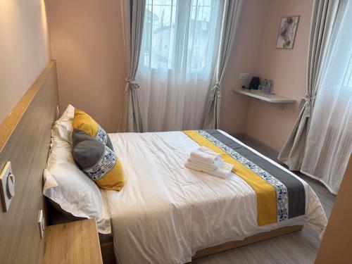 a bedroom with a bed with towels on it at Chambre pour 2 personnes dans la banlieue parisienne (Bondy) in Bondy