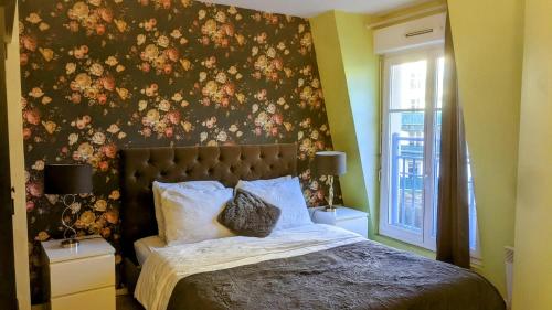 a bedroom with a bed with a floral wall at Val d'EuropeApart in Chessy