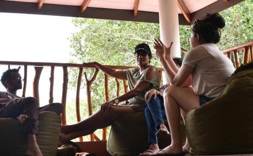 a group of people sitting on a porch at Funky Leopard Safari Lodge Bordering Yala National Park in Kataragama
