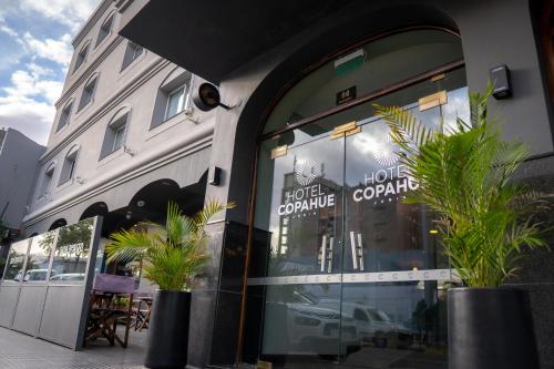 a store front with plants in front of a building at Hotel Copahue in Junín