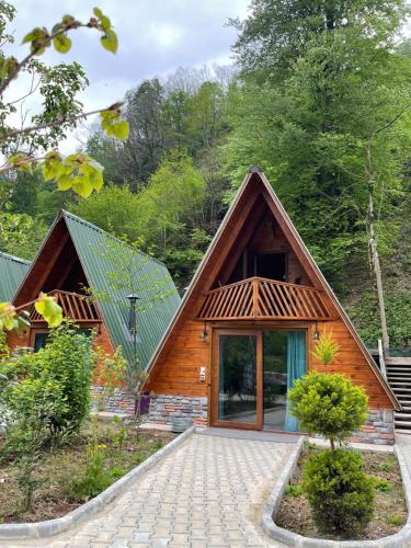 una pequeña casa de madera con techo de paja en Tanura Bungalows en Çamlıhemşin