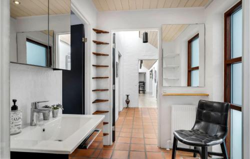 a bathroom with a sink and a black chair at Beautiful Home In Kjellerup With Kitchen in Kjellerup