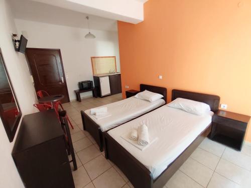 Duas camas num quarto com paredes cor de laranja em Galini Studios & apartments Laganas em Laganas