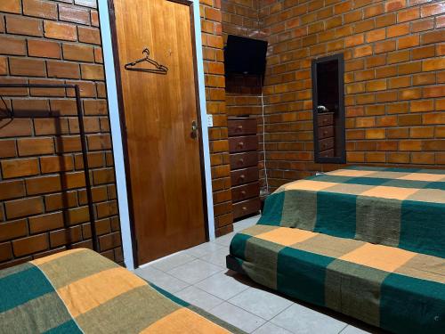 a room with two beds in a brick wall at Casa aconchegante e equipada em Gravatá in Gravatá