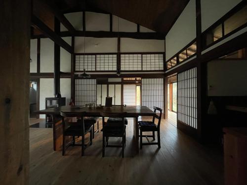 ein Esszimmer mit einem großen Holztisch und Stühlen in der Unterkunft 菜を｜NAWO in Goto