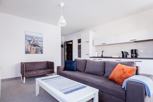 a living room with a couch and a table at AWO Apartamenty in Łeba