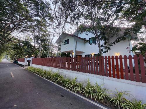 a white house behind a red fence at Bann White Chalet Khaoyai in Mu Si