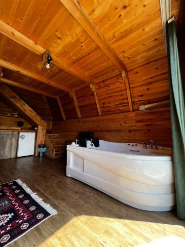 um quarto com uma cama branca num tecto de madeira em Serintepe Bungalov em Çamlıhemşin