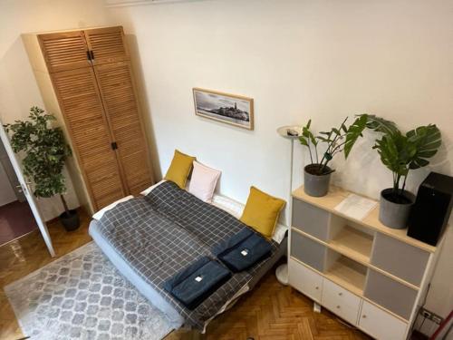 a bedroom with a bed and a dresser with plants at Awesome, 15 mins to center home in Budapest