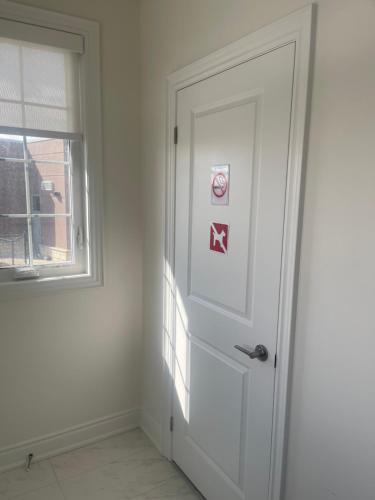 a white door with a no smoking sign next to a window at Unwind Here in a Stylish and Cozy Space in Bradford