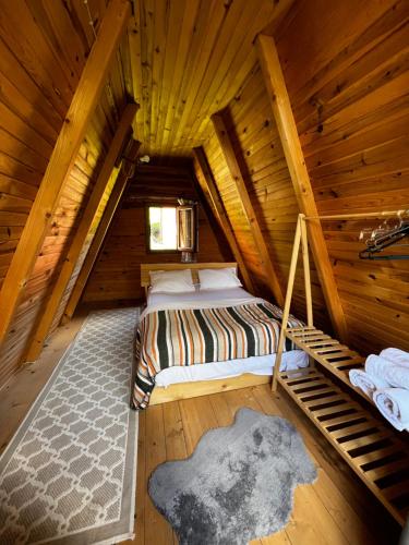 a bedroom with a bed in a wooden cabin at Serintepe Bungalov in Çamlıhemşin