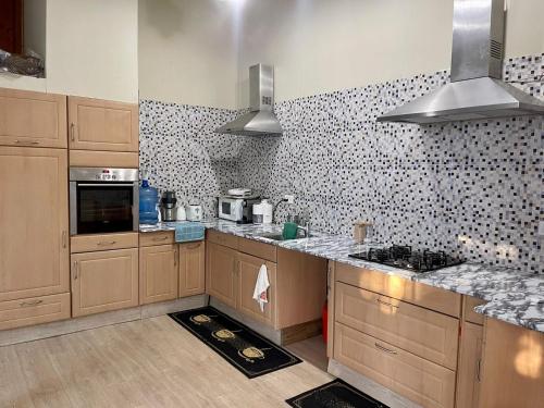 a kitchen with wooden cabinets and a tile wall at Casa Mano Juan in Mano Juan