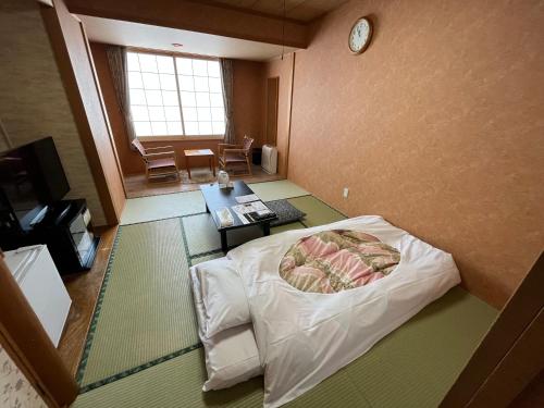 紋別市にある紋別プリンスホテルのベッドと壁に時計がある部屋