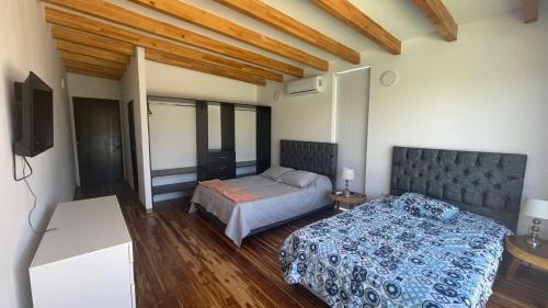 een slaapkamer met 2 bedden en een televisie. bij VILLA KITE Habitaciones cuadruples LUJO , SALINAS DEL REY in Juan de Acosta