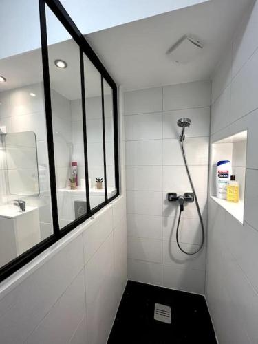 La salle de bains blanche est pourvue d'une douche et d'une fenêtre. dans l'établissement Moderne appartement - Gare - centre-ville, au Mans