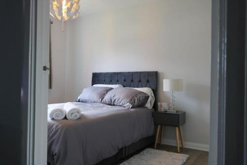 1 dormitorio con 1 cama con 2 toallas en Lovely flat with Wi-Fi and free parking en Reading