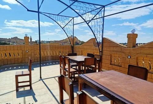 a patio with tables and chairs on a roof at Addas Home in Siwa