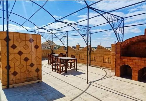 een patio met een tafel en stoelen op een dak bij Addas Home in Siwa