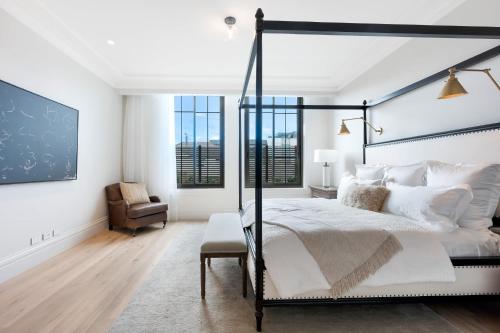 a bedroom with a bed and a chair and windows at The California Romantic - Residence 3 in Melbourne