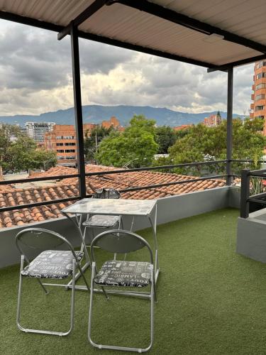 a table and two chairs on a roof at Aparta estudio amoblado 3 Medellin, San joaquin in Medellín